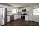 Well-lit kitchen boasts stainless steel appliances, granite countertops, subway tile backsplash, and hardwood flooring at 4704 Apache Sw Trl, Atlanta, GA 30331