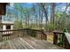 Wooden deck with railing overlooks a wooded backyard with a small shed at 4980 W Chapel Hill Rd, Douglasville, GA 30135