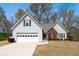 Charming two-story home with white siding, brick accents, attached garage, and a well-manicured front yard at 1545 Heatherton Rd, Dacula, GA 30019