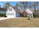 Charming two-story home with white siding, brick accents, attached garage, and a well-manicured front yard at 1545 Heatherton Rd, Dacula, GA 30019