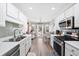 Bright, modern galley kitchen boasts stainless steel appliances, ample cabinets, and backyard access at 1545 Heatherton Rd, Dacula, GA 30019