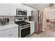 Close up of a modern kitchen featuring stainless steel appliances, ample counter space, and stylish white cabinets at 1545 Heatherton Rd, Dacula, GA 30019