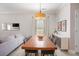 Stylish dining room with a long wood table, buffet, and a modern light fixture over light wood flooring at 2240 Arnold Mill Nw Rd, Lawrenceville, GA 30044