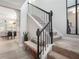 Bright entryway featuring an staircase with dark banister, bench seating, and views into the open concept living area at 2240 Arnold Mill Nw Rd, Lawrenceville, GA 30044