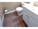Bathroom featuring wood look floors, a toilet, and a vanity with a white countertop and cabinets at 3903 Cain Mill Dr, Lithonia, GA 30038