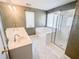 Well-lit bathroom showcasing a large mirror, double sinks, bathtub, and a glass door shower at 3903 Cain Mill Dr, Lithonia, GA 30038