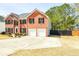Side view of two-story brick home featuring an attached two-car garage and large driveway at 3903 Cain Mill Dr, Lithonia, GA 30038