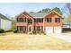 Charming two-story brick home featuring an attached two-car garage and meticulously maintained landscaping at 3903 Cain Mill Dr, Lithonia, GA 30038