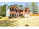 Exterior view of two-story brick home featuring an attached two-car garage and well-maintained lawn at 3903 Cain Mill Dr, Lithonia, GA 30038