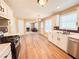 Kitchen with stainless steel appliances, double sink, and white cabinets that opens to living area with fireplace at 3903 Cain Mill Dr, Lithonia, GA 30038