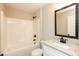 Well-lit bathroom featuring a shower-tub combo and a granite-topped vanity with modern fixtures at 482 West Ave, Bowdon, GA 30108
