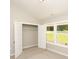 Bedroom boasts natural light, a closet with an open door, and neutral carpet flooring at 482 West Ave, Bowdon, GA 30108