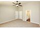 Bright bedroom with neutral carpet, a ceiling fan, and access to the en-suite bathroom at 482 West Ave, Bowdon, GA 30108