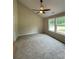 Bedroom with carpet, ceiling fan, and view to the yard from the large window at 482 West Ave, Bowdon, GA 30108
