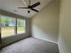 Bedroom with carpet, ceiling fan, and view of the yard from the large windows at 482 West Ave, Bowdon, GA 30108