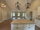 Open concept living and kitchen area, featuring granite island and modern pendant lights at 482 West Ave, Bowdon, GA 30108
