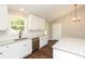 Bright kitchen features white cabinets, stainless appliances, granite countertops, and hardwood floors at 482 West Ave, Bowdon, GA 30108