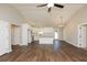 Open concept living space boasts wood floors and bright kitchen with island and stainless steel appliances at 482 West Ave, Bowdon, GA 30108