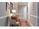 Long hallway with accent chair, decorative runner, and neutral paint at , Atlanta, GA 30305
