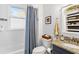 Cozy updated bathroom features built-in shelving, shower/tub combination, with granite counters and a gray vanity at 1514 Rogers Sw Ave, Atlanta, GA 30310