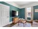 Charming living room with dark teal walls, modern furniture, and refinished hardwood floors at 1514 Rogers Sw Ave, Atlanta, GA 30310