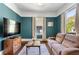 Comfortable living room featuring teal walls, a large window, neutral paint, and modern furniture at 1514 Rogers Sw Ave, Atlanta, GA 30310
