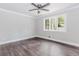 Bedroom with dark wood-look floors, neutral walls, crown molding, and natural light at 247 Old Timber Rd, Lawrenceville, GA 30046