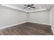 A spacious bedroom features a tray ceiling with a fan and wood-look tile flooring at 247 Old Timber Rd, Lawrenceville, GA 30046