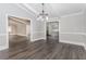 Open-concept dining area with wood floors, elegant lighting, and views into the kitchen and living spaces at 247 Old Timber Rd, Lawrenceville, GA 30046