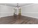 Elegant dining area featuring wood floors, wainscoting, crown molding, and an ornate chandelier for a sophisticated touch at 247 Old Timber Rd, Lawrenceville, GA 30046