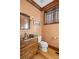 Charming powder room features a decorative vanity, custom window and brass fixtures at 6316 Woodlake Dr, Buford, GA 30518