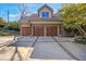 Stone home with a large driveway leading to a spacious three-car garage with wooden doors at 6316 Woodlake Dr, Buford, GA 30518