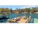 Lake view from a boat dock featuring outdoor seating and a grill, surrounded by autumn trees at 6316 Woodlake Dr, Buford, GA 30518