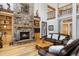 Cozy living room with a stone fireplace and comfortable leather furniture and two-story ceilings at 6316 Woodlake Dr, Buford, GA 30518