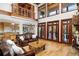 Bright living room featuring hardwood floors, a stone fireplace, and large windows at 6316 Woodlake Dr, Buford, GA 30518