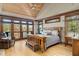Spacious bedroom with lake views from the large windows and doors, wood ceiling, trim and floors at 6316 Woodlake Dr, Buford, GA 30518