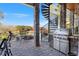 Covered patio with an outdoor grill, spiral staircase, lake view and stone pillars at 6316 Woodlake Dr, Buford, GA 30518