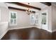 Dining area with dark wood floors, wood beams, chandelier, and natural light from the windows at 319 Riverton Way, Woodstock, GA 30188