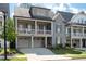 Attractive two-story home showcasing a welcoming front porch, attached garages, and lush landscaping at 319 Riverton Way, Woodstock, GA 30188