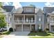 Charming two-story home featuring a welcoming front porch, attached garage and manicured lawn at 319 Riverton Way, Woodstock, GA 30188
