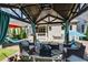Covered outdoor lounge with comfortable seating and view of the manicured backyard and patio at 319 Riverton Way, Woodstock, GA 30188