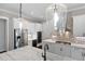 Modern kitchen with stainless steel appliances, white cabinets, granite countertops, and stylish hanging lights at 319 Riverton Way, Woodstock, GA 30188