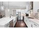 Bright, open kitchen featuring stainless steel appliances, shaker cabinets, and a large island with seating at 319 Riverton Way, Woodstock, GA 30188