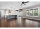 Bright living room features a view into the modern kitchen, hardwood floors, and large windows providing ample natural light at 319 Riverton Way, Woodstock, GA 30188
