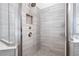 Beautiful, tiled shower with a rainfall showerhead and built-in shelving at 319 Riverton Way, Woodstock, GA 30188