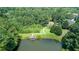 Aerial view of a property with a dock on the lake surrounded by lush trees at 4710 Mcintosh Dr, Cumming, GA 30040