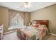 Cozy bedroom featuring a wood frame bed with a colorful quilt and ample natural light through the windows at 4710 Mcintosh Dr, Cumming, GA 30040