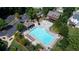 Aerial view shows a community pool with seating, a clubhouse, and parking for residents at 4710 Mcintosh Dr, Cumming, GA 30040