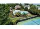 Aerial view of a community pool, tennis court, and clubhouse surrounded by lush greenery at 4710 Mcintosh Dr, Cumming, GA 30040