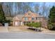 Well-maintained brick home with lush landscaping, mature trees, and a side-entry garage at 4710 Mcintosh Dr, Cumming, GA 30040